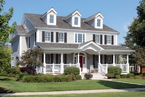 White house with gray roof shingles windows gutters siding front porch